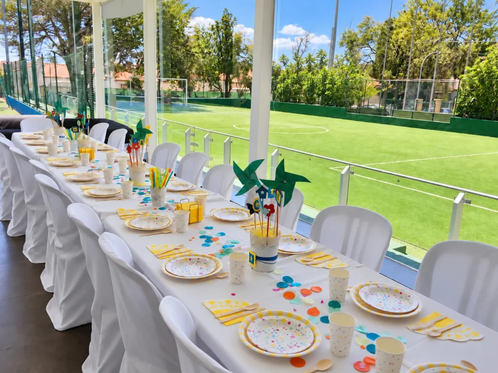 Mesa decorada para una celebración junto al campo de fútbol.